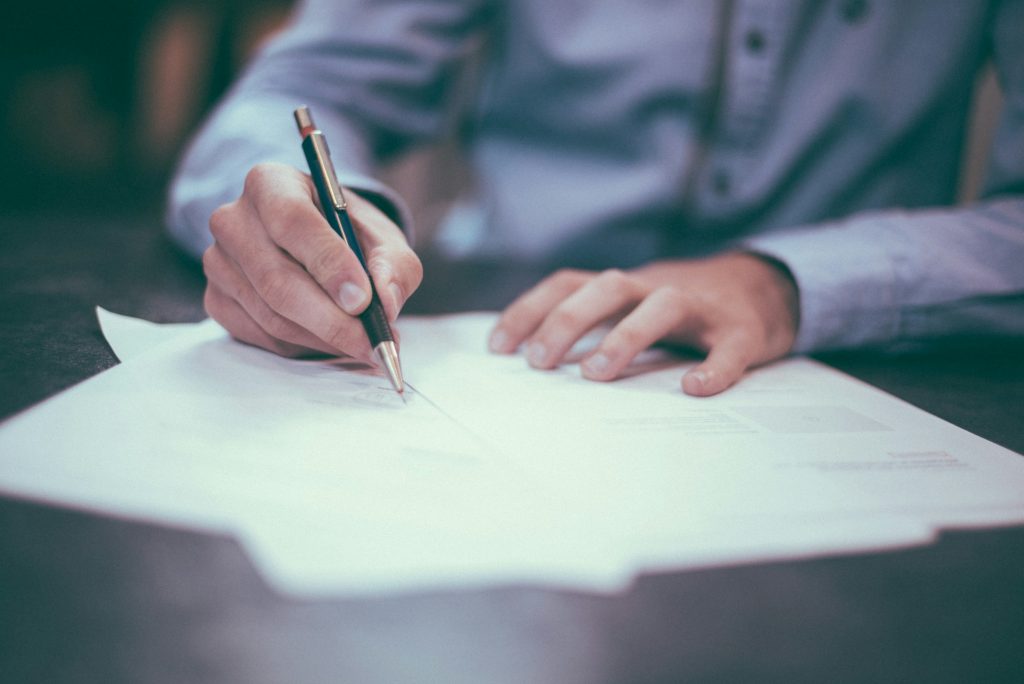Man using pen to write on paper