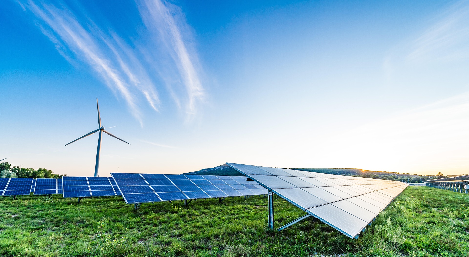 Solar panels with wind turbine in background