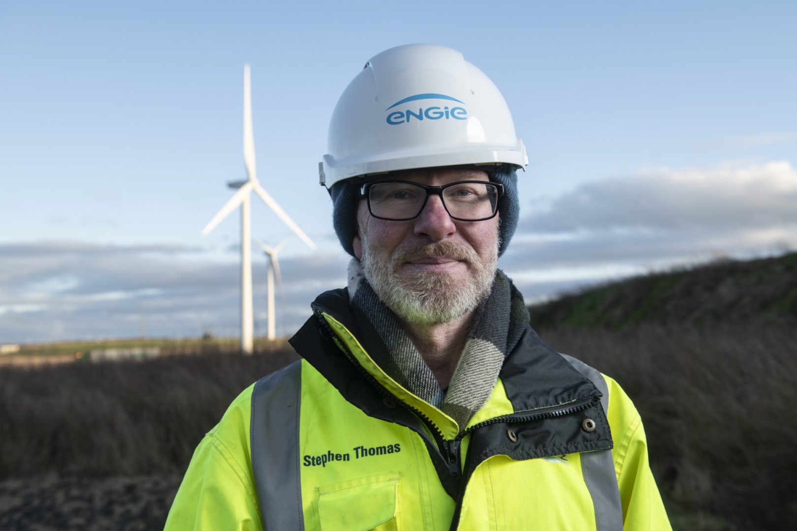 Man standing in front of ENGIE wind turbine