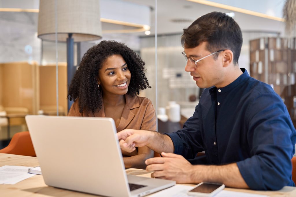 Diverse team professional employees working together on computer in office.