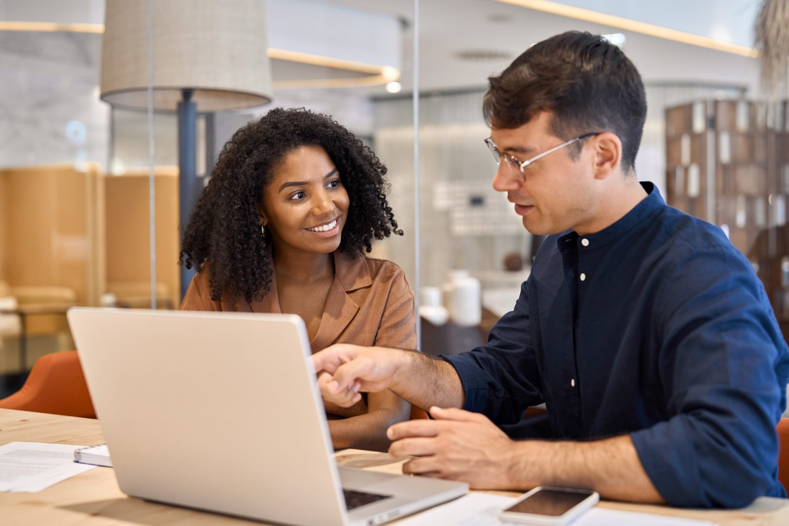 Diverse team professional employees working together on computer in office.